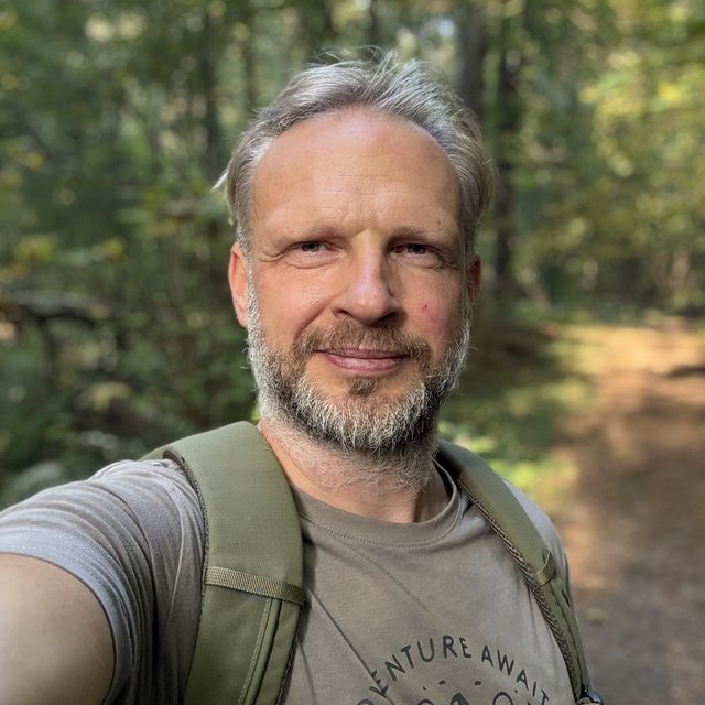 Arnas Dilys smiling on a forest path